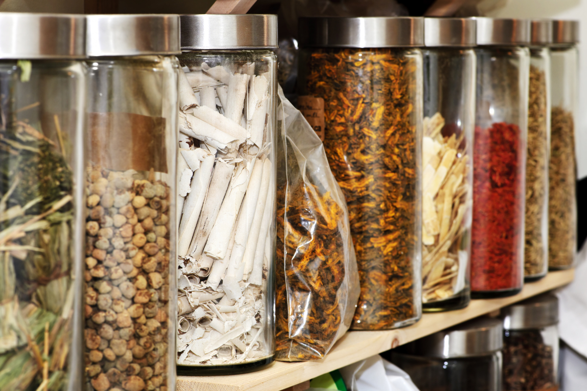 a shelf filled with jars filled with different types of spices .
