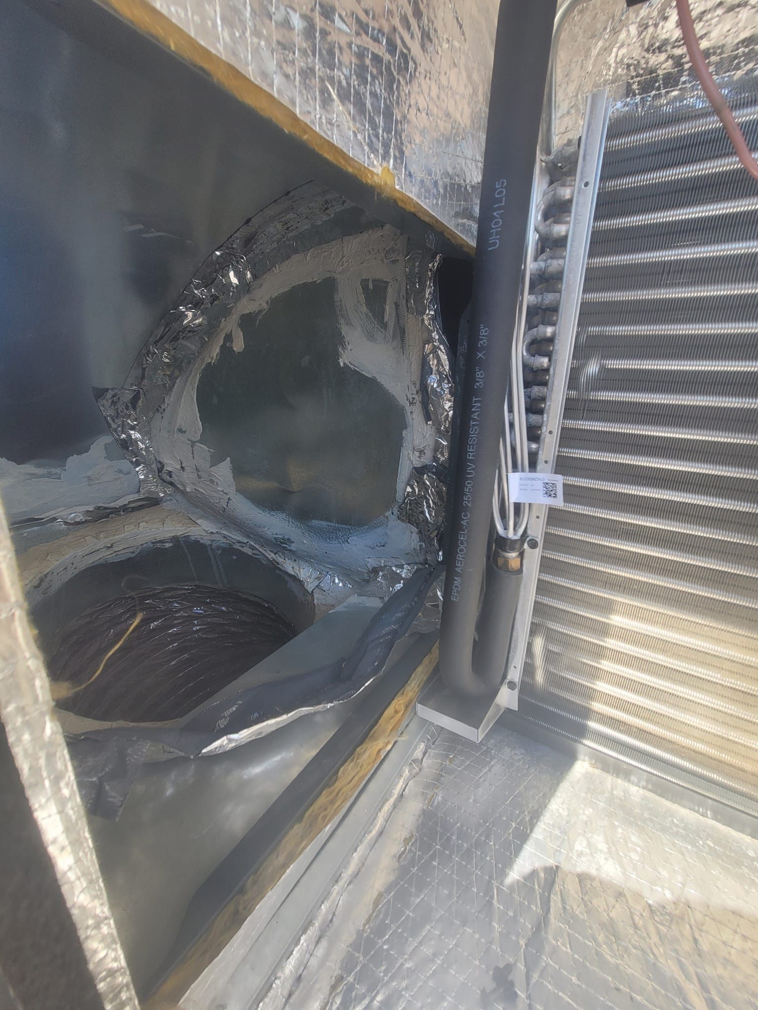 Black and silver HVAC unit interior. Water and corrosion visible on metal components.