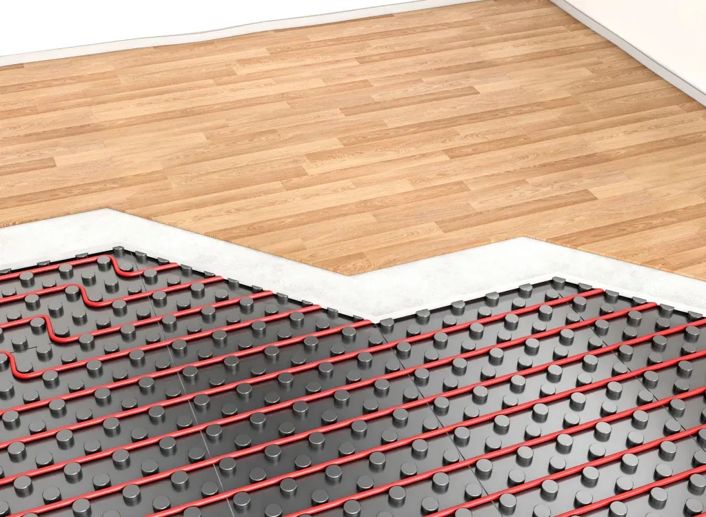 Sectioned view of a room with radiant floor heating system: red tubing on black panels beneath a wooden floor.