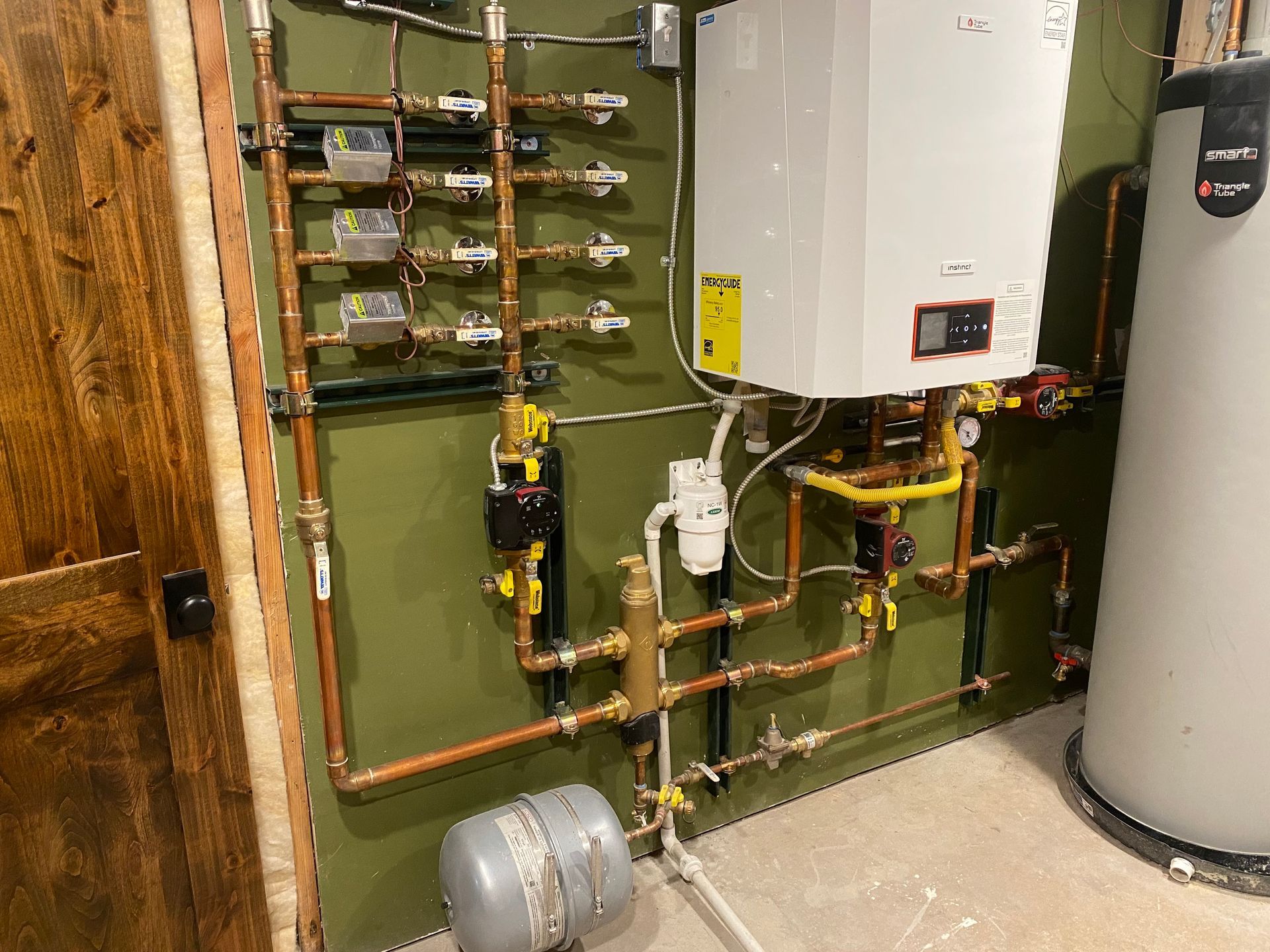 A room with a boiler and a water heater in it.