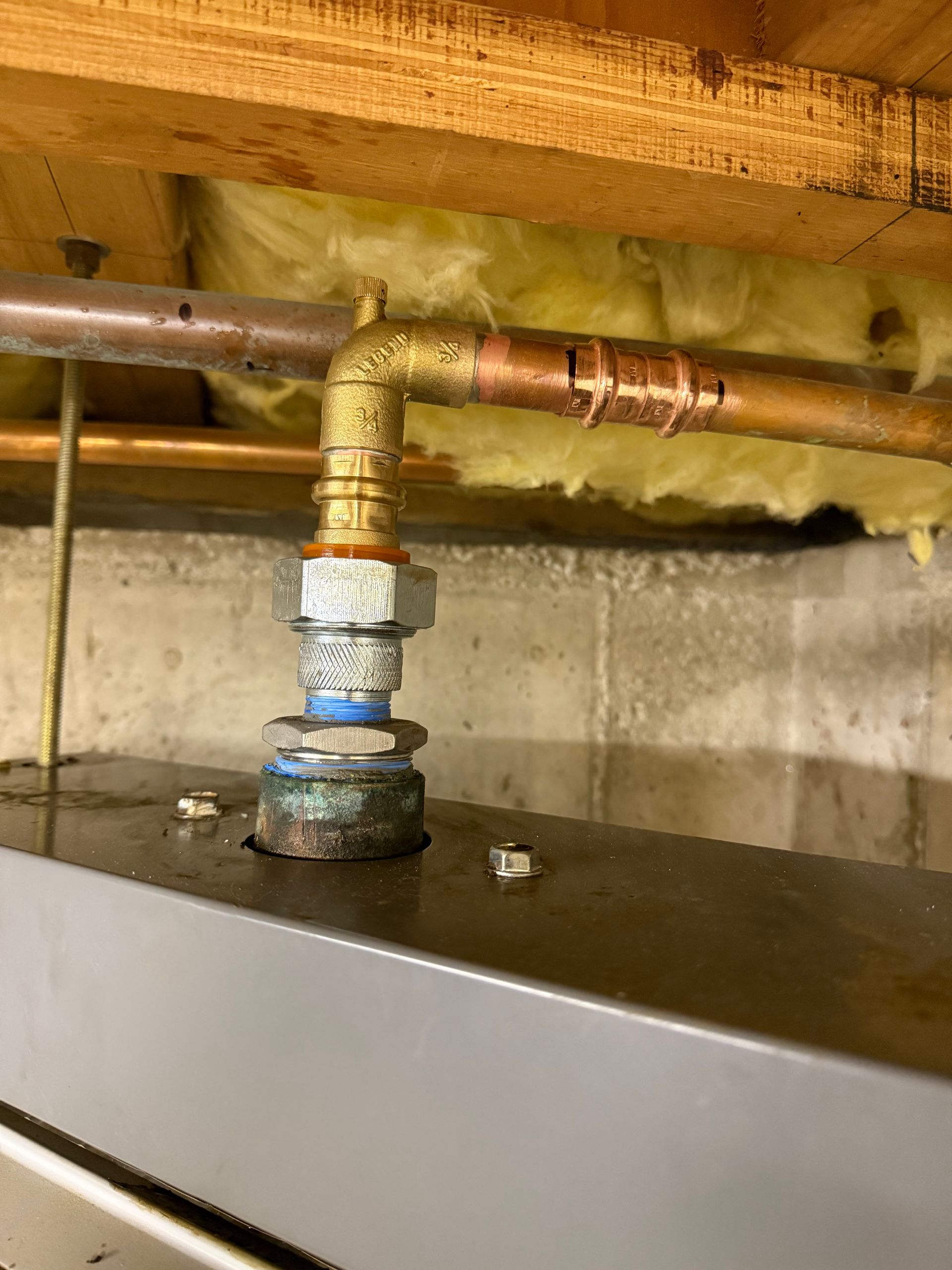 A close up of a copper pipe in a basement.