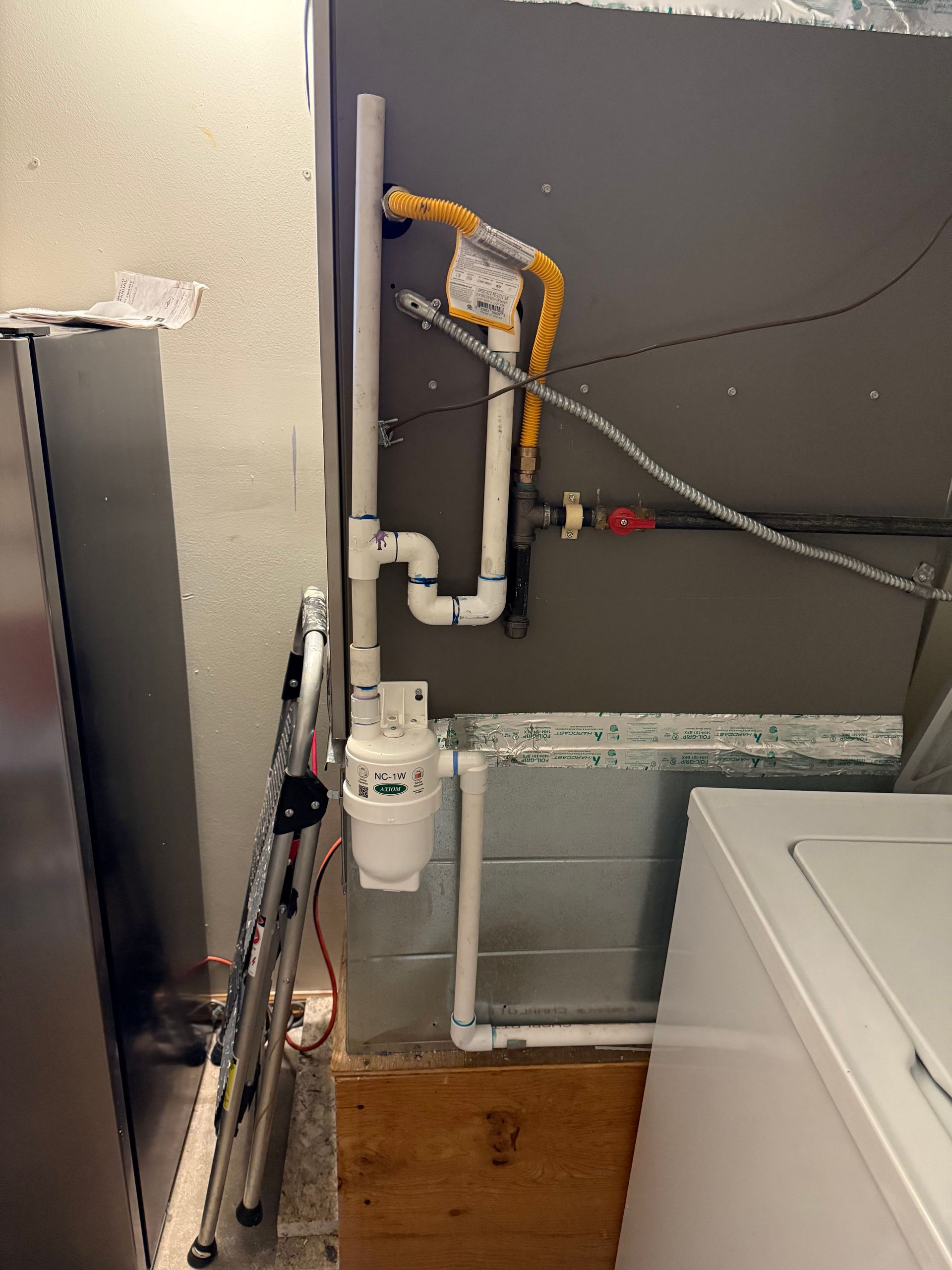 A laundry room with a washer and dryer and a gas meter.