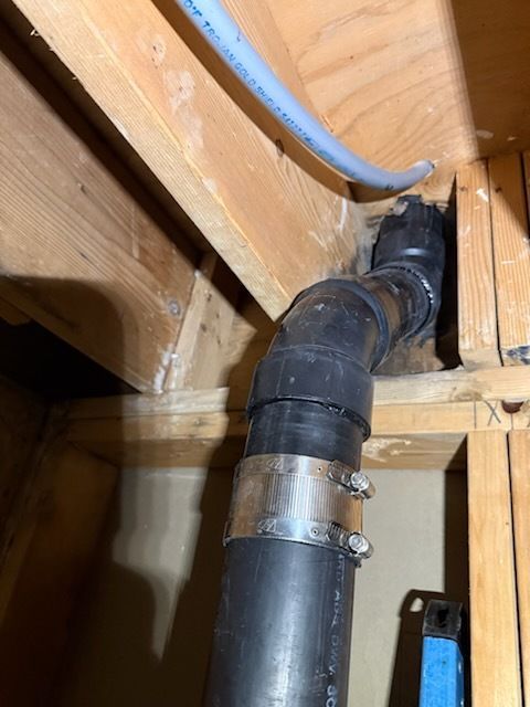 A black pipe is going through a wooden structure.