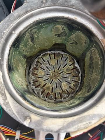 A close up of a dirty metal object with a hole in the middle.