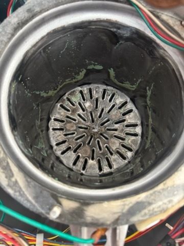 A close up of a metal object with a hole in the middle surrounded by wires.