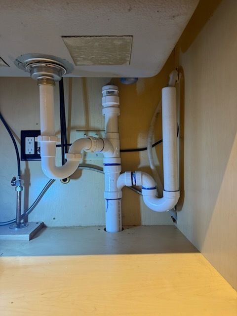 A sink with a lot of pipes underneath it.