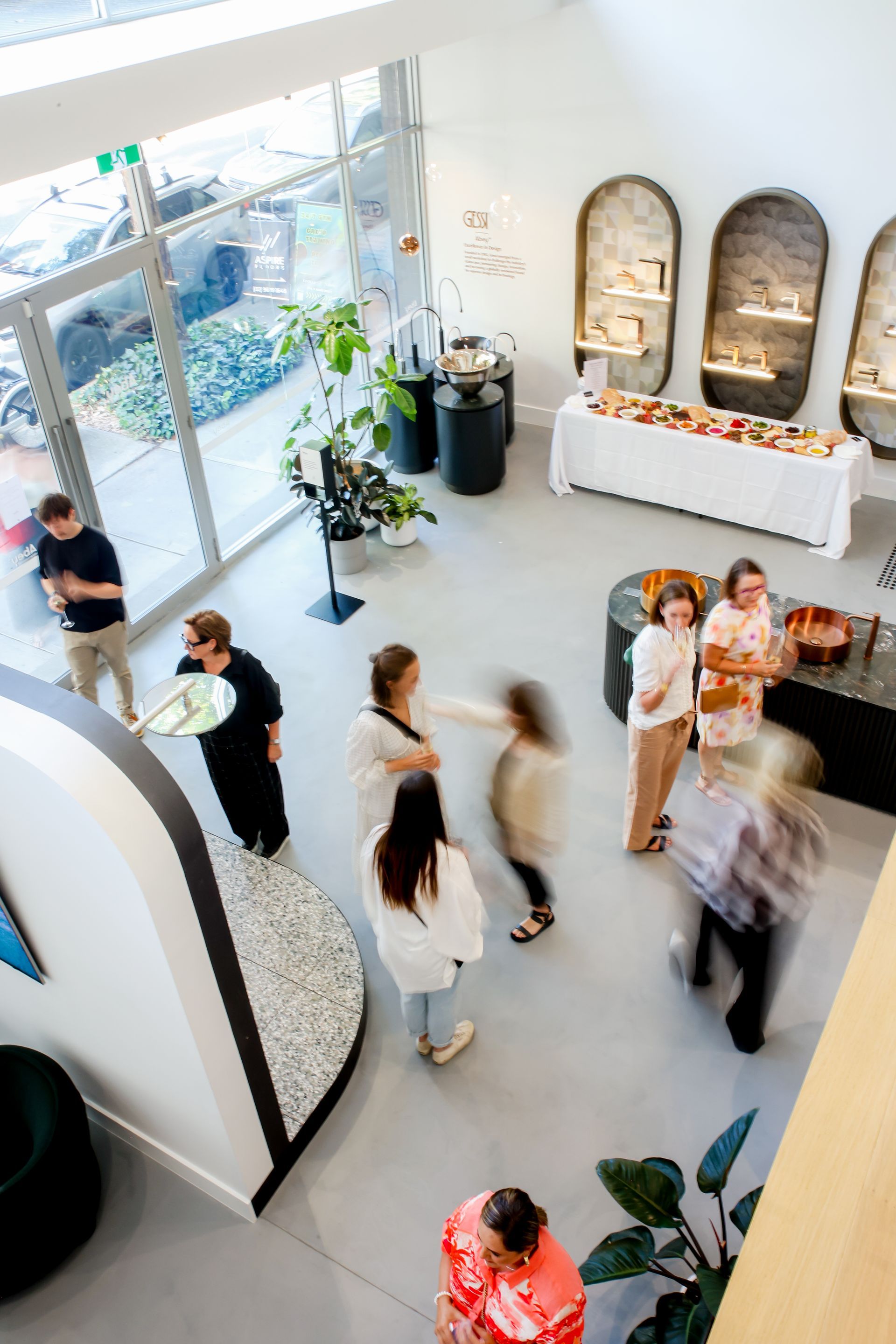 Interior view of a modern shop with customers browsing displays and refreshments.