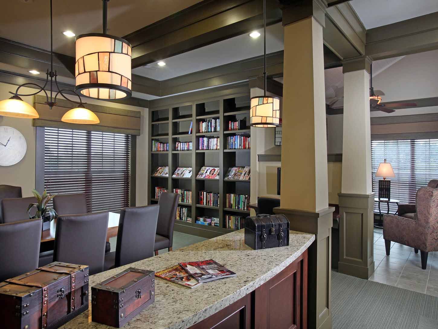 Communal lounge with library shelves, seating, and a granite counter.