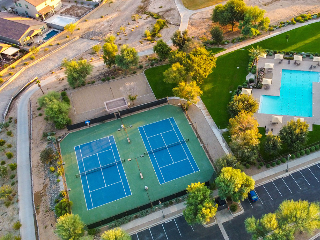 An aerial view of a tennis court and a swimming pool.