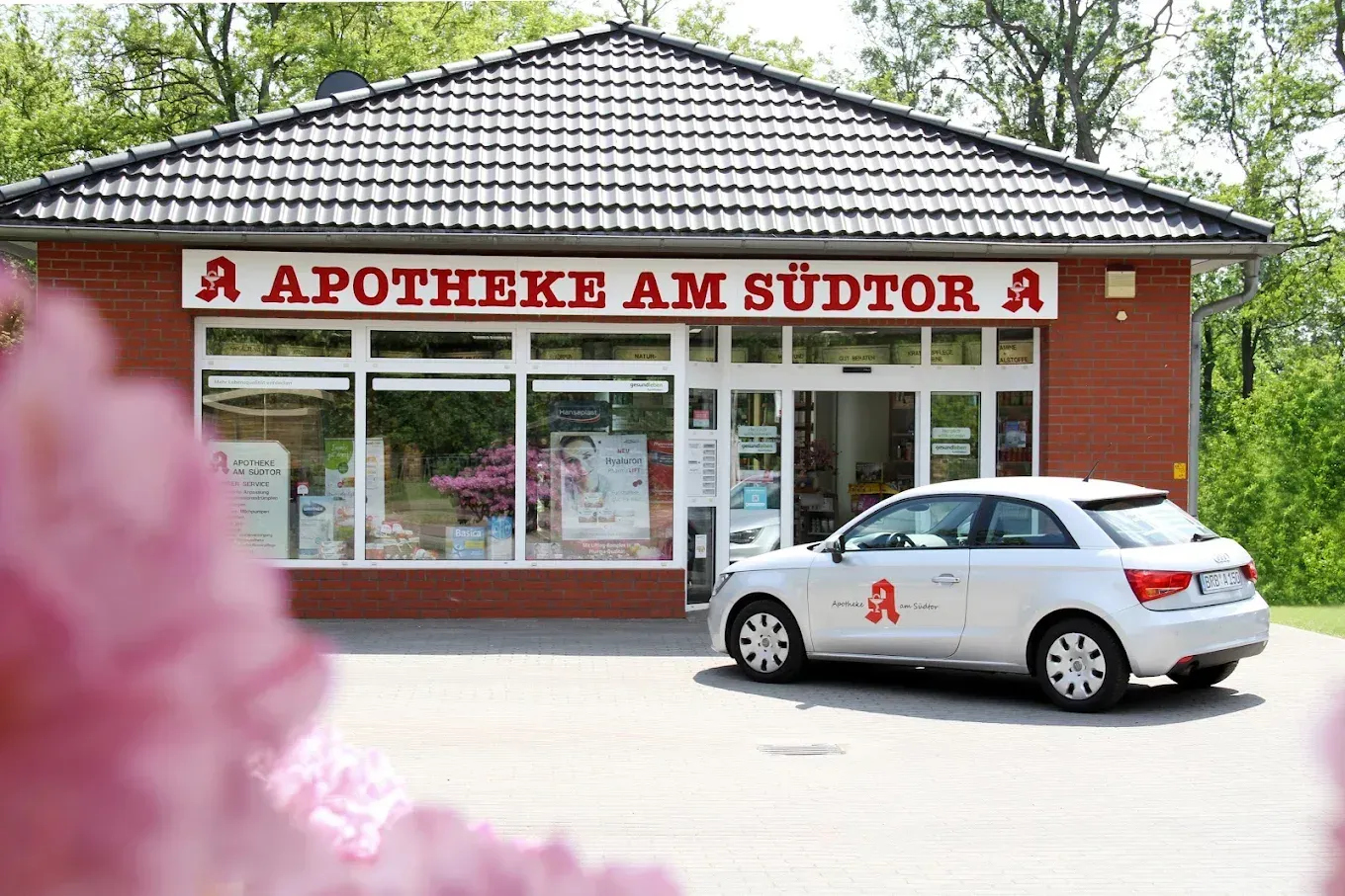 Innenansicht einer Apotheke mit Produktregalen, Theken und Auslagen.