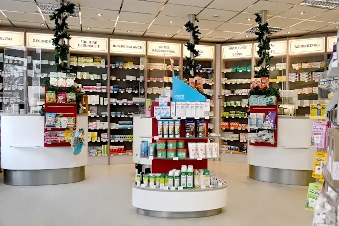 Innenansicht einer Apotheke mit Produktregalen, Theken und Auslagen.