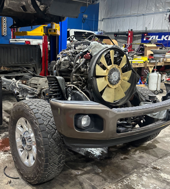A brown pickup truck chassis with an exposed engine being worked on in an auto repair shop | Marshside Motors