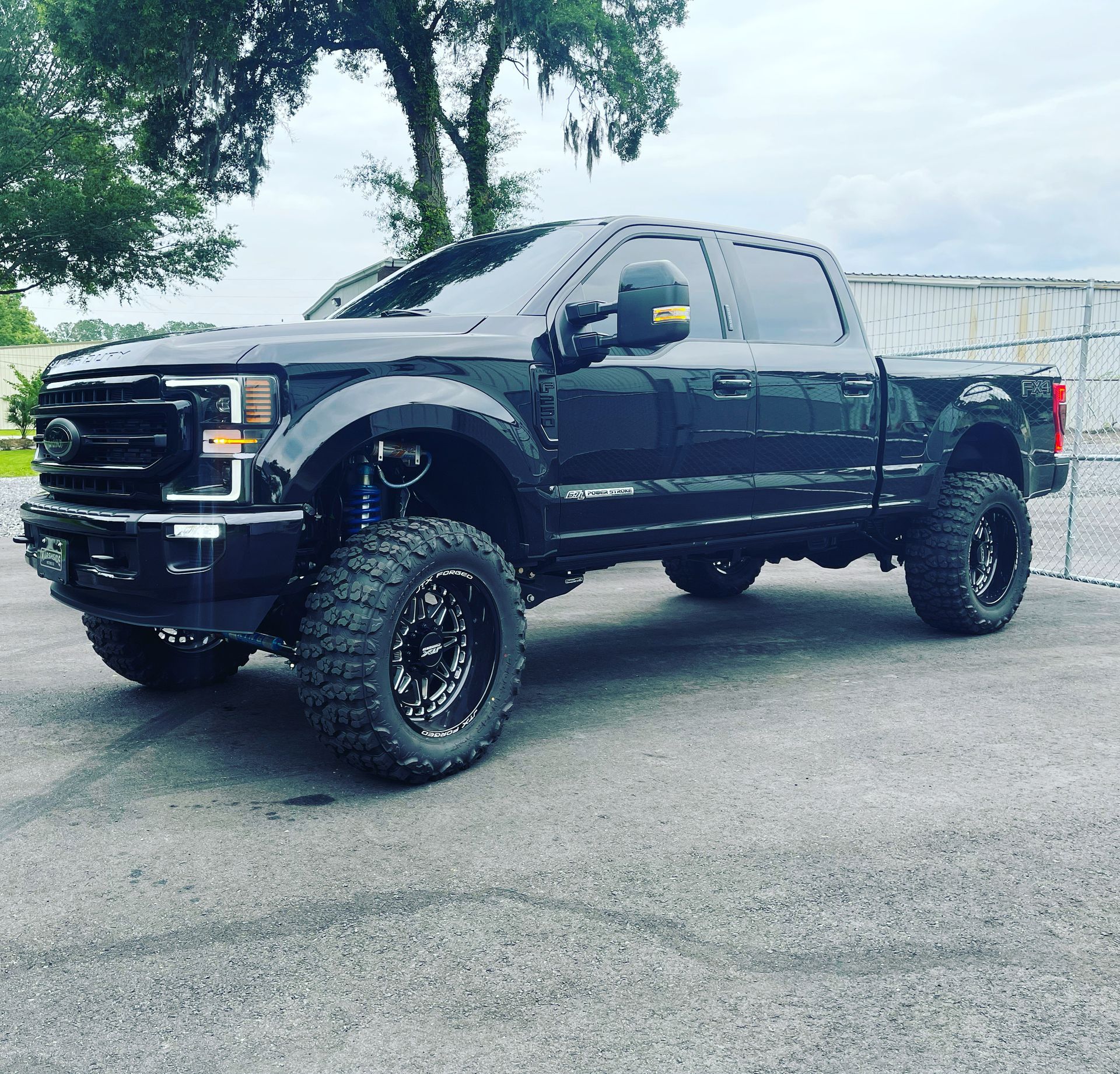Black lifted Ford truck parked on pavement | Marshside Motors