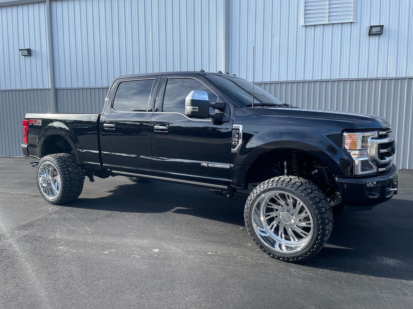 Black Ford pickup truck with chrome wheels and tinted windows parked outside | Marshside Motors