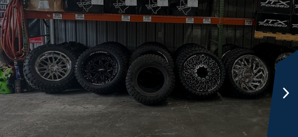 A row of tires with different wheel designs in a garage | Marshside Motors