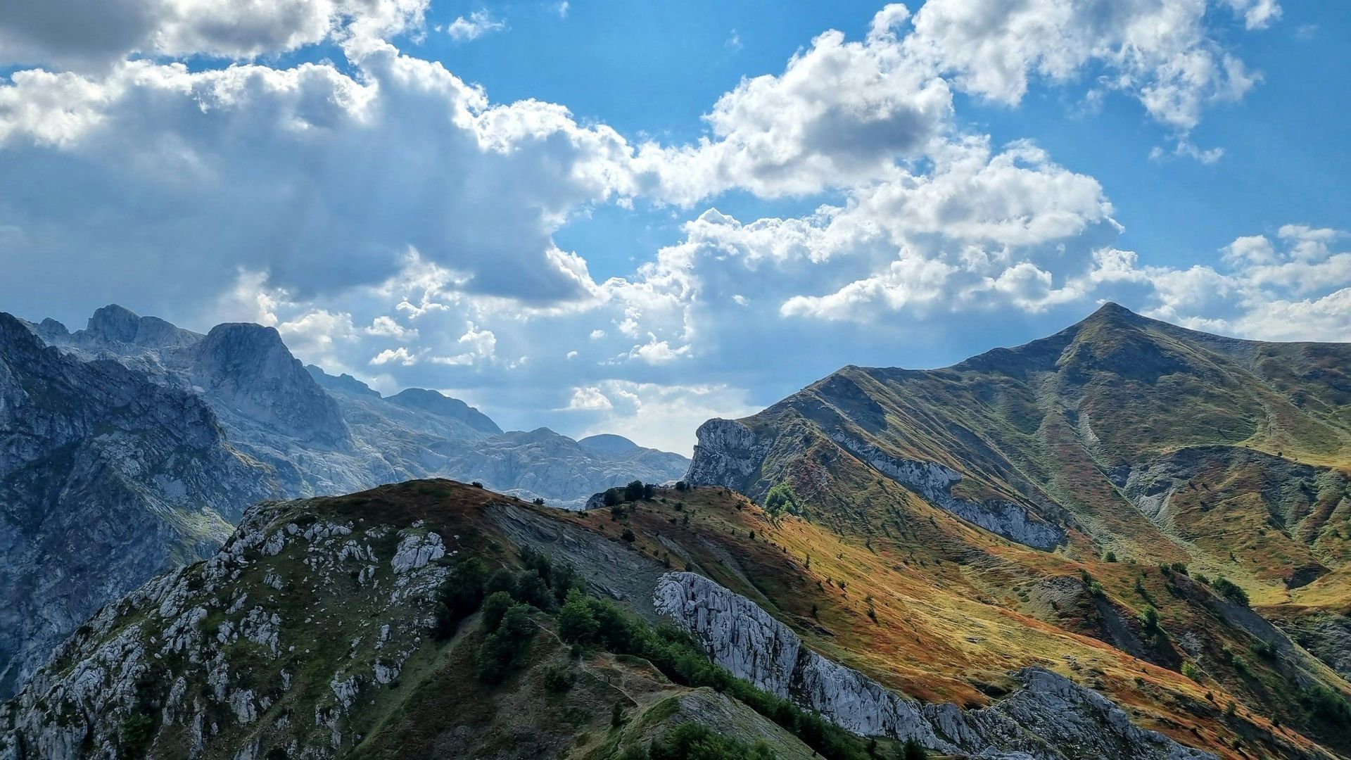 Rugged mountain range under a partly cloudy blue sky.