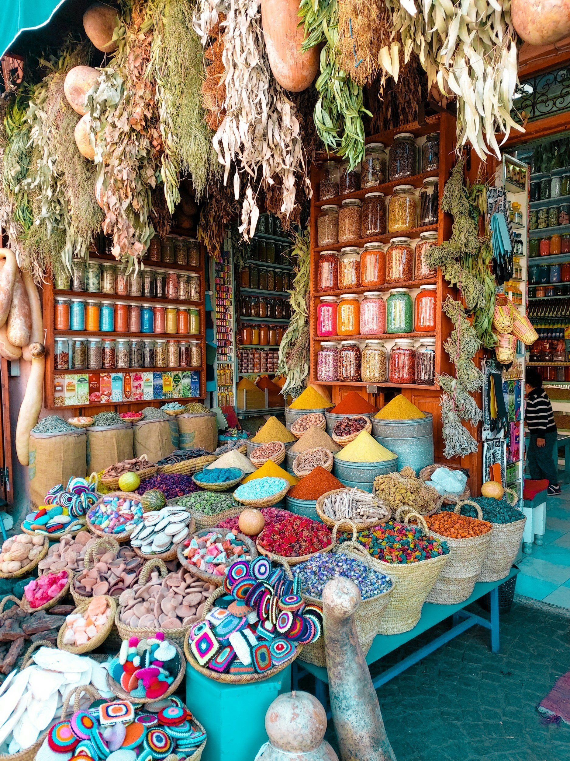Spice market stall with colorful spices, jars, and dried herbs hanging.