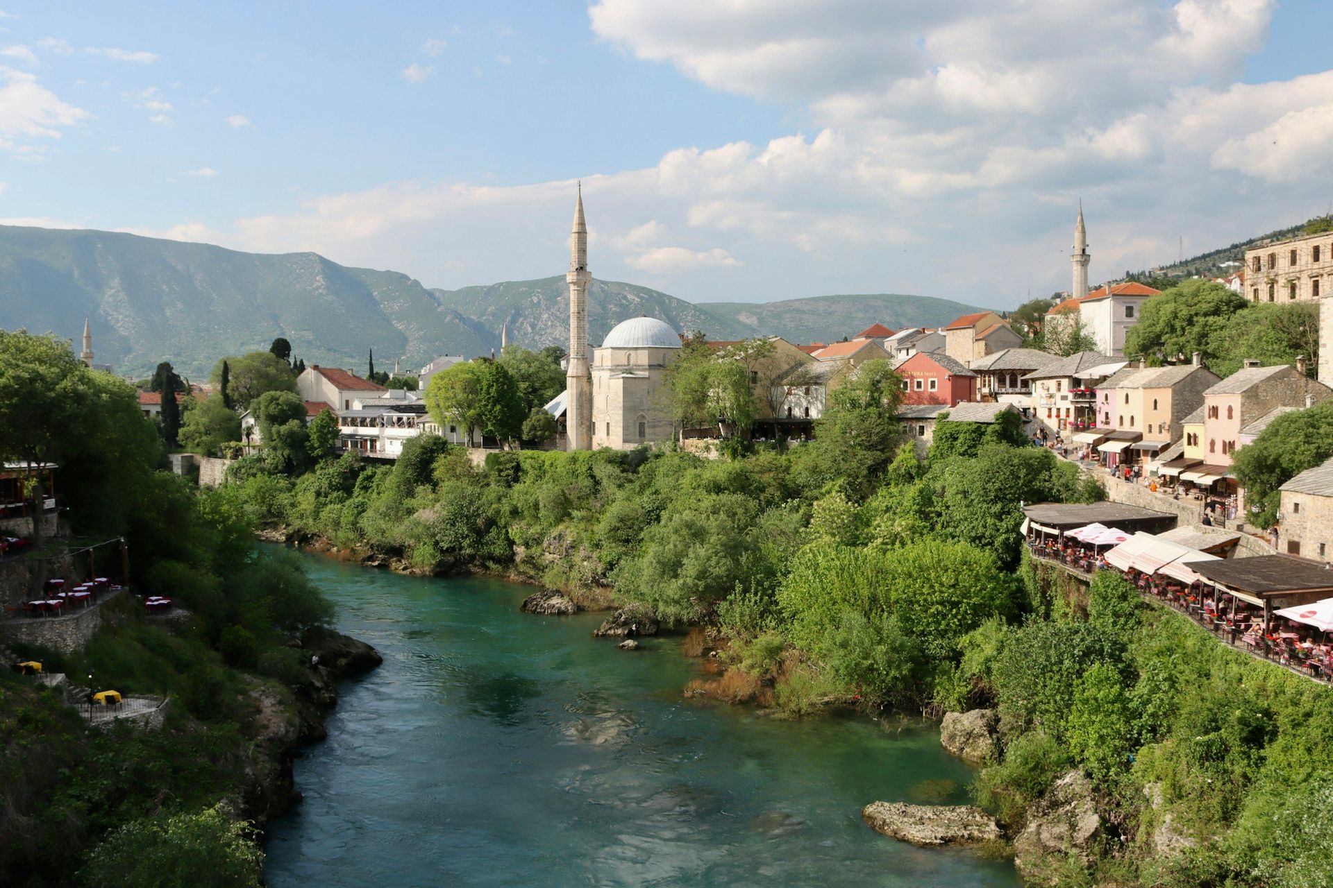 View of Mostar, Bosnia and Herzegovina, with a turquoise river, buildings, and a mosque.