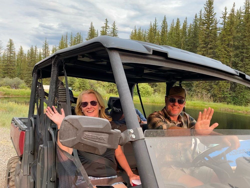 A man and a woman are sitting in a atv.