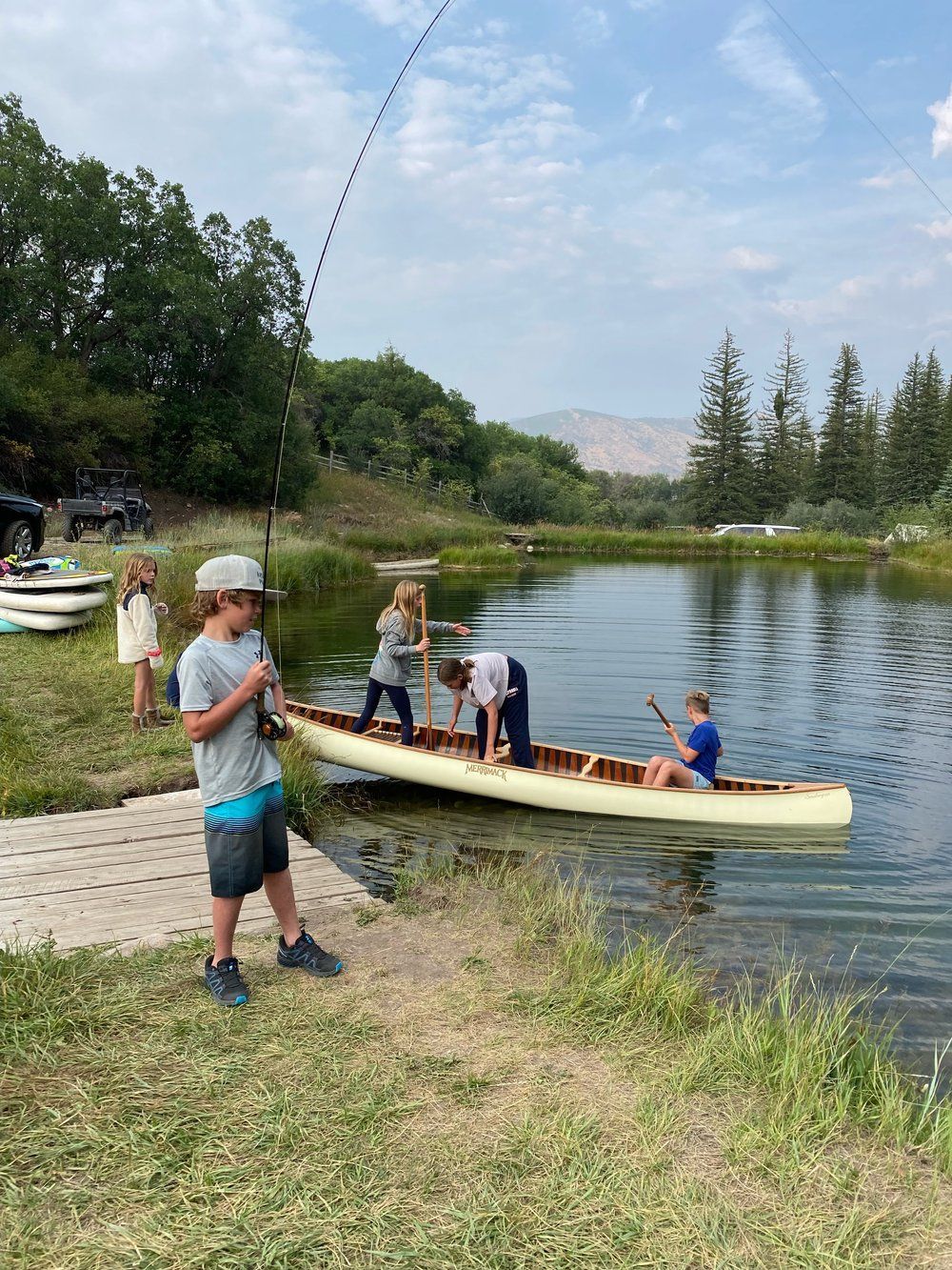 A group of children are fishing in a lake.