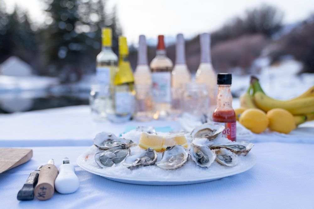 There is a plate of oysters on ice on the table.