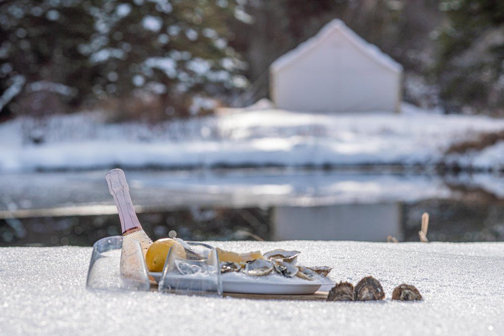 A bottle of champagne is sitting on top of a snow covered surface.