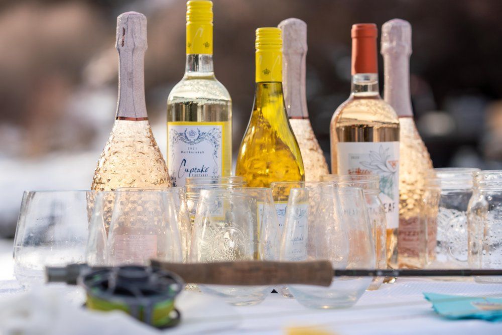 A row of wine bottles and glasses on a table.