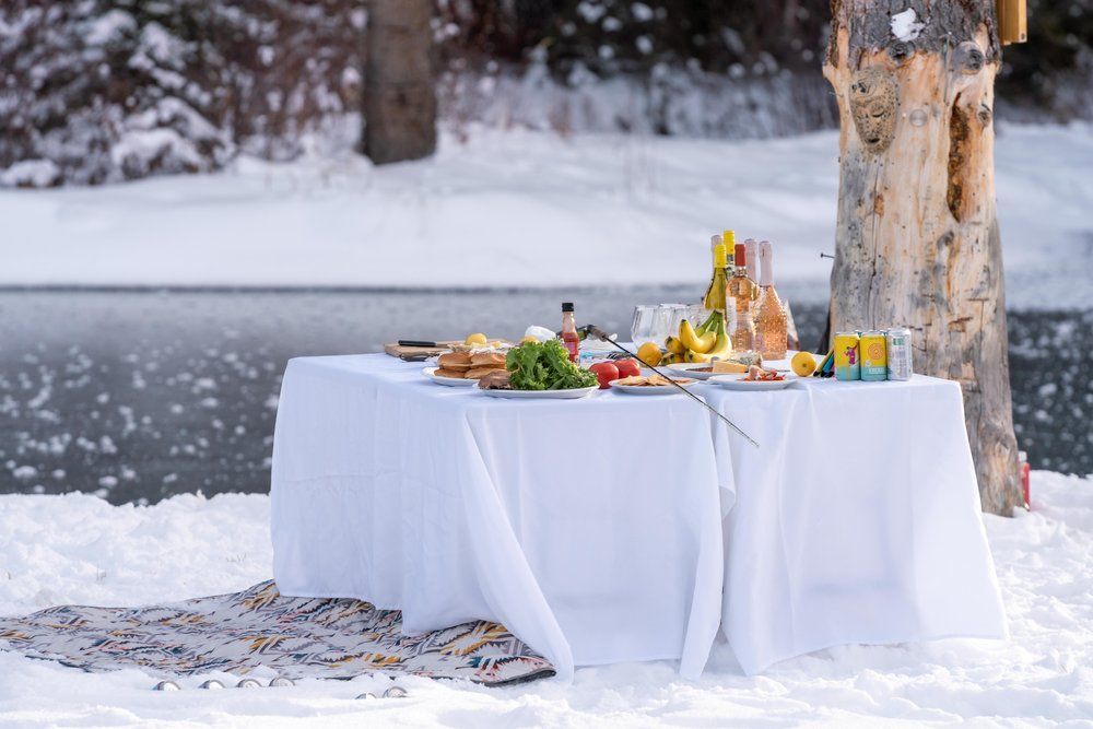 There is a table with food on it in the snow.