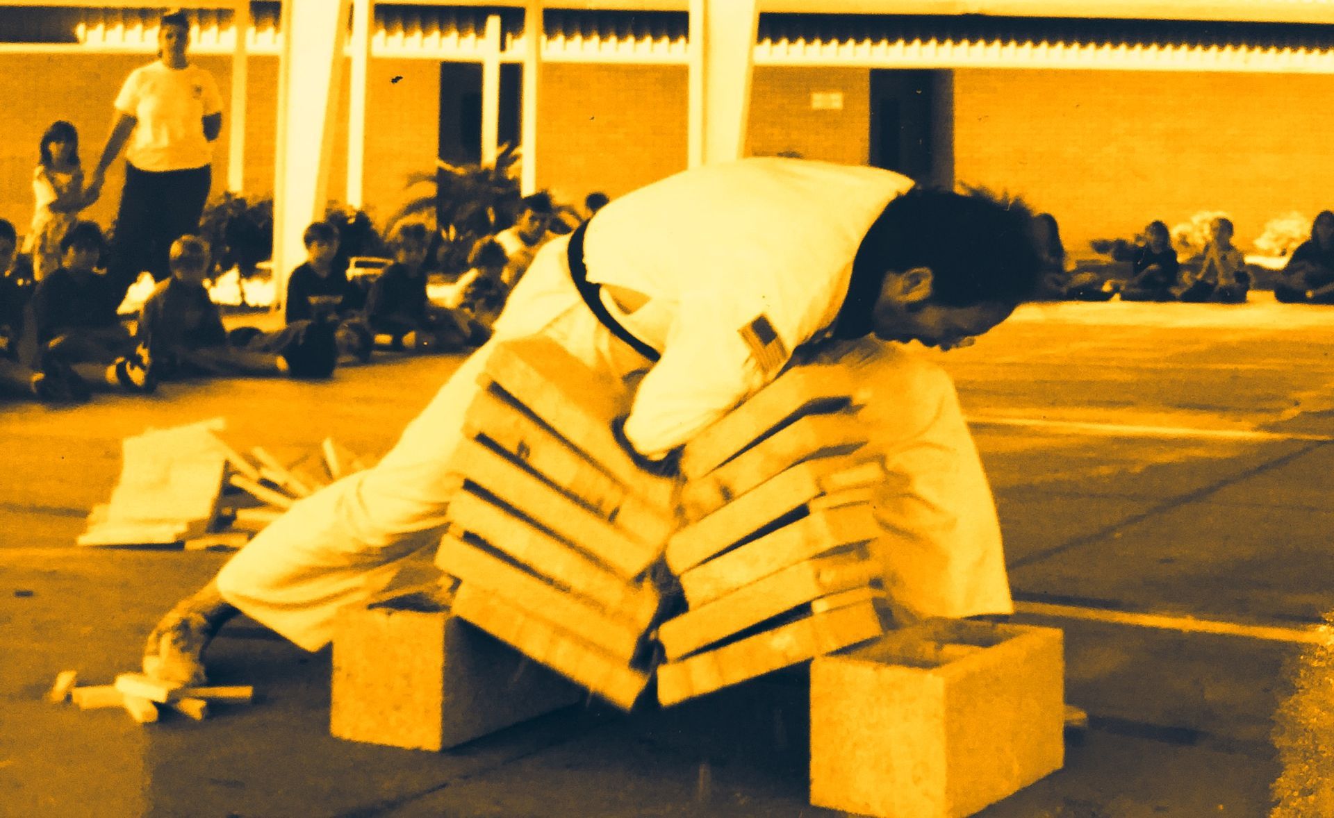 A man is carrying a stack of wooden crates on his back