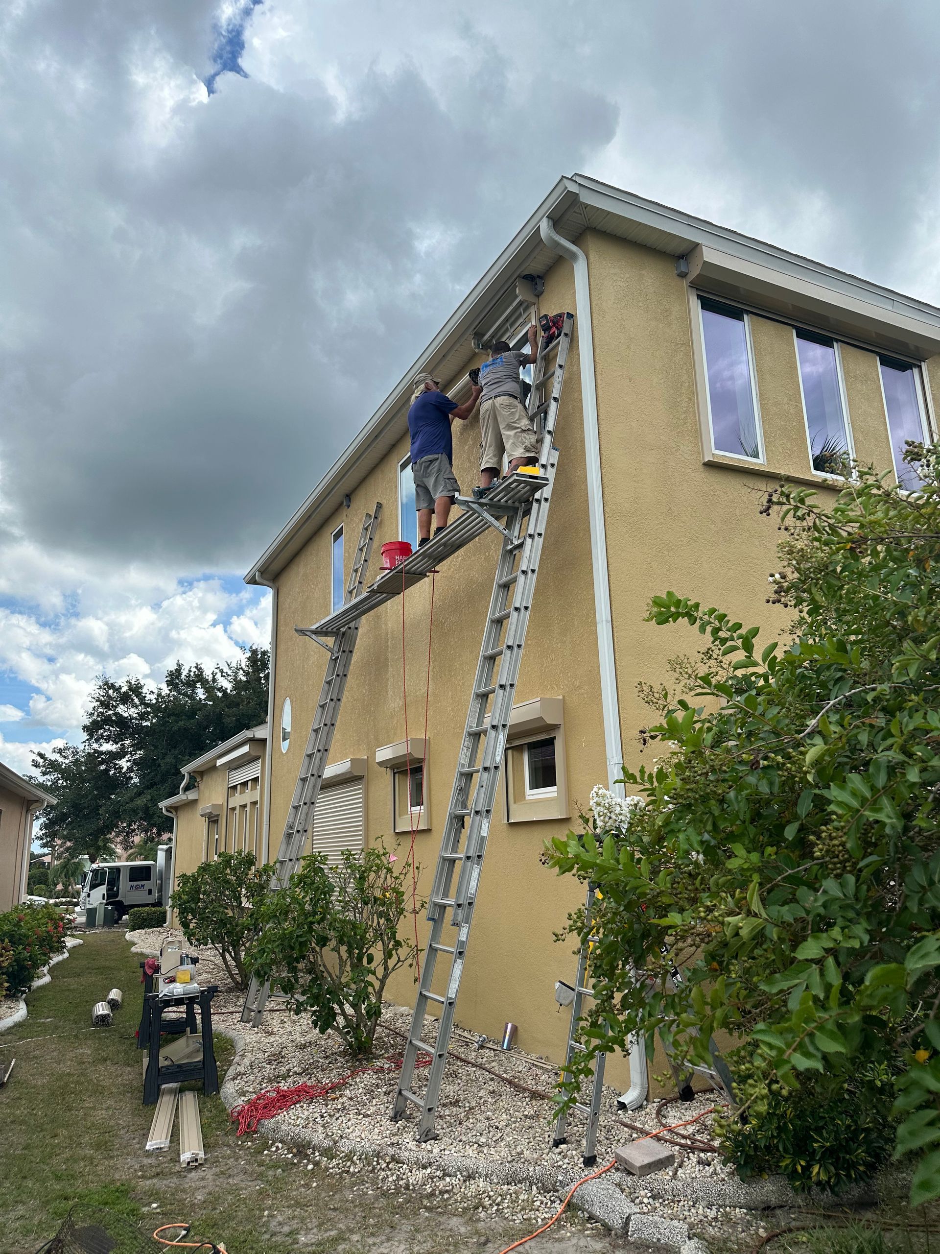 A group of people are painting the side of a house.