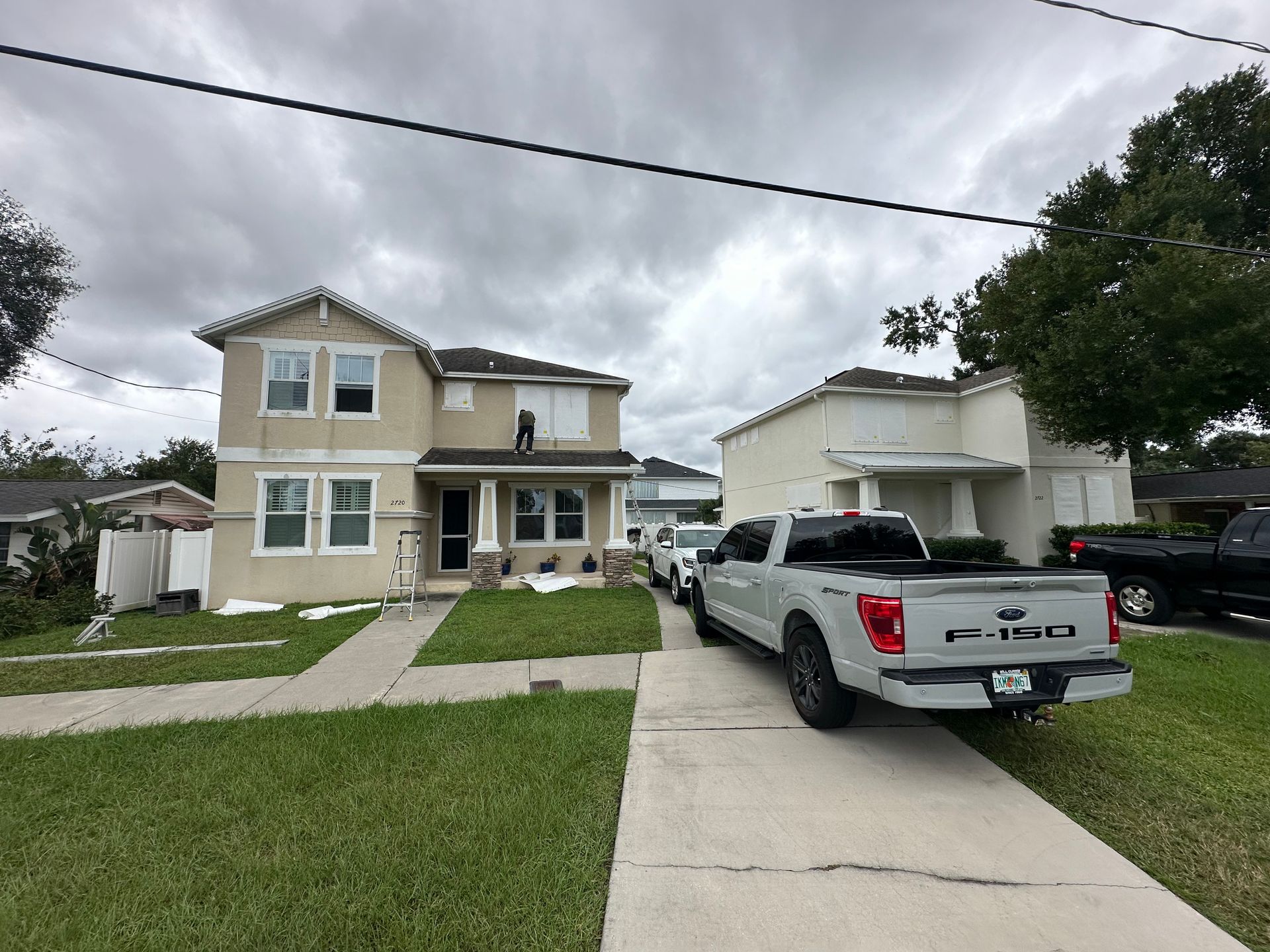 A white ford truck is parked in front of a house.