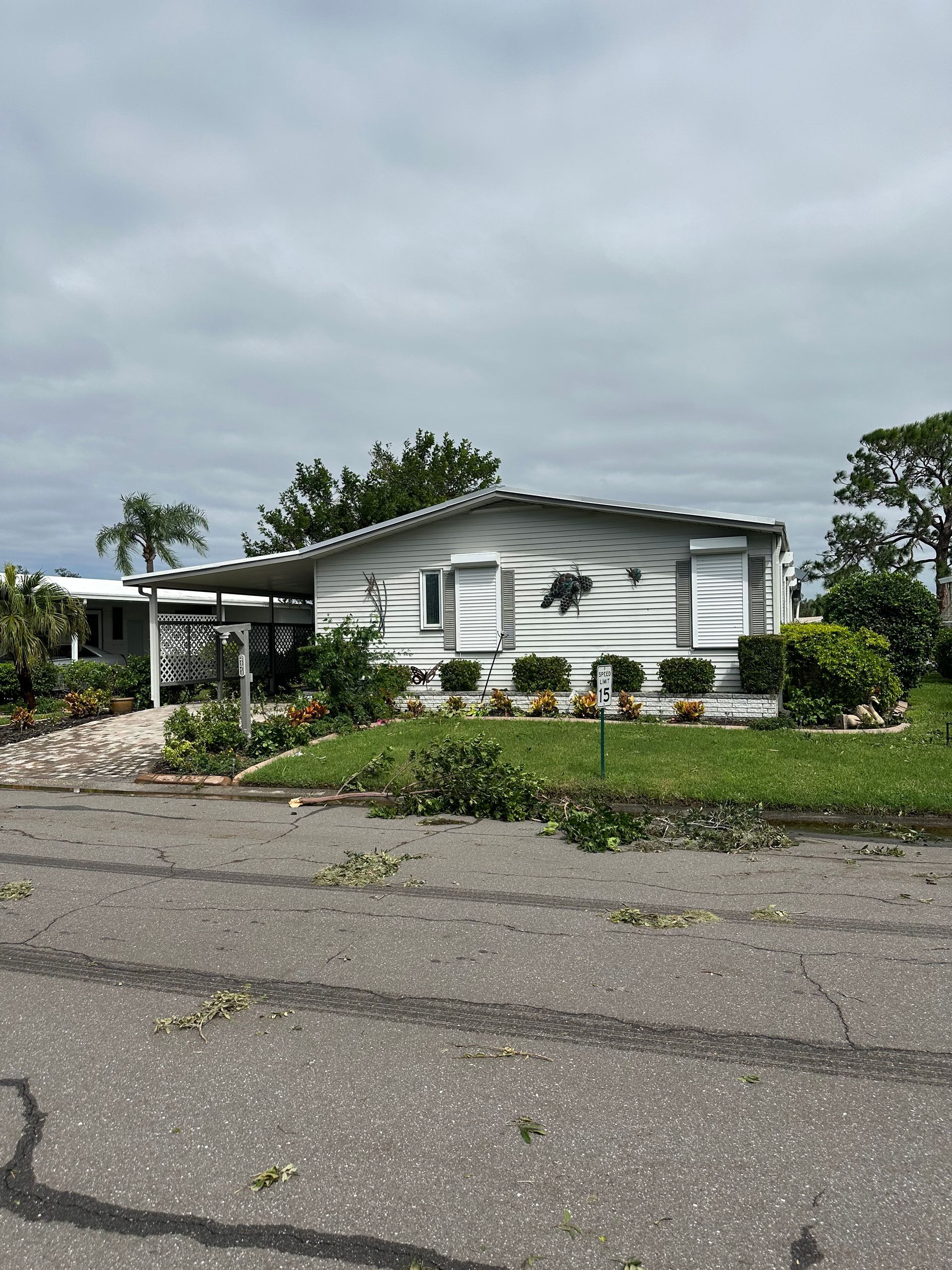 A white mobile home is sitting on top of a grassy hill.