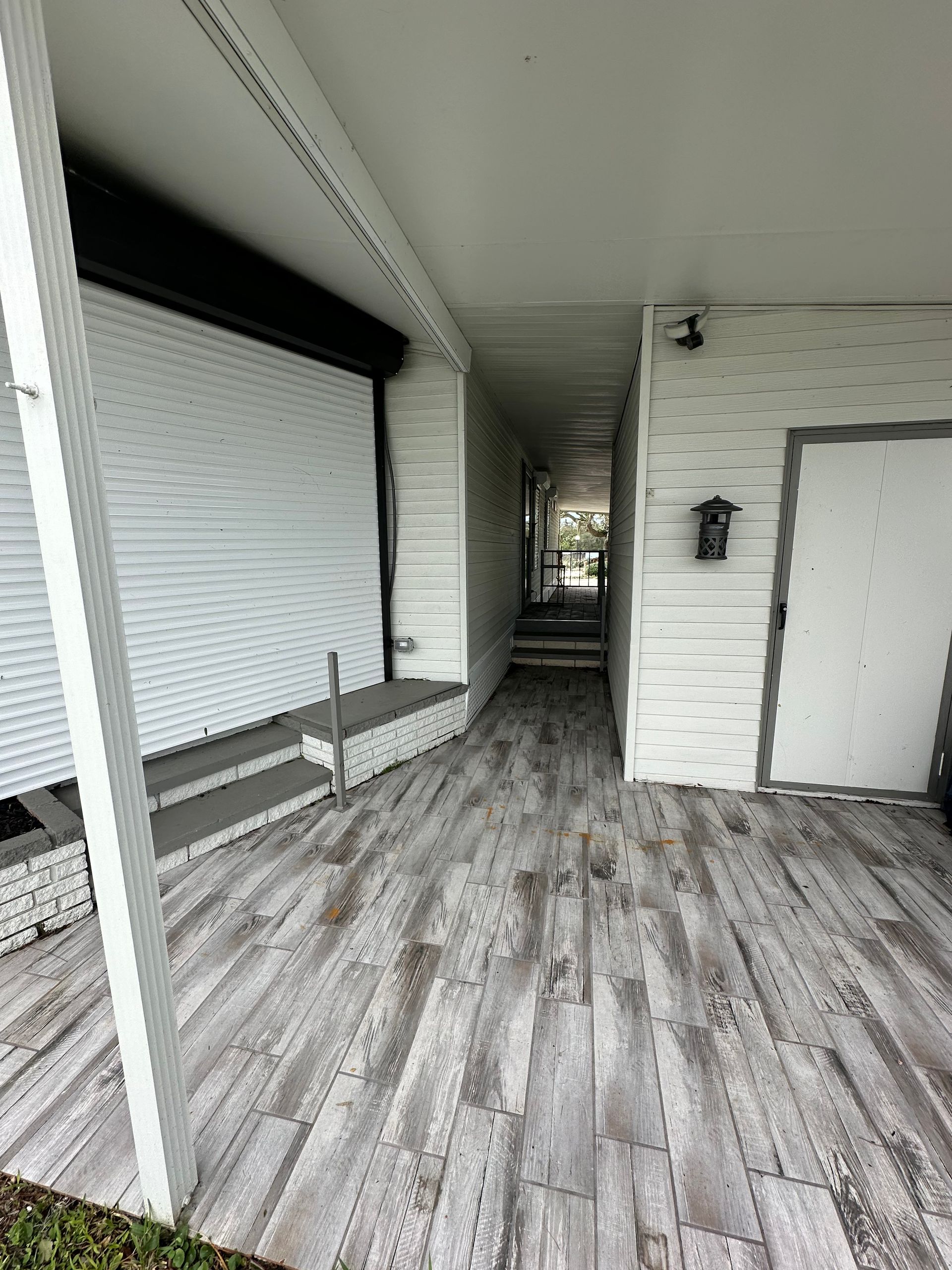 A white house with a wooden floor and a covered porch.