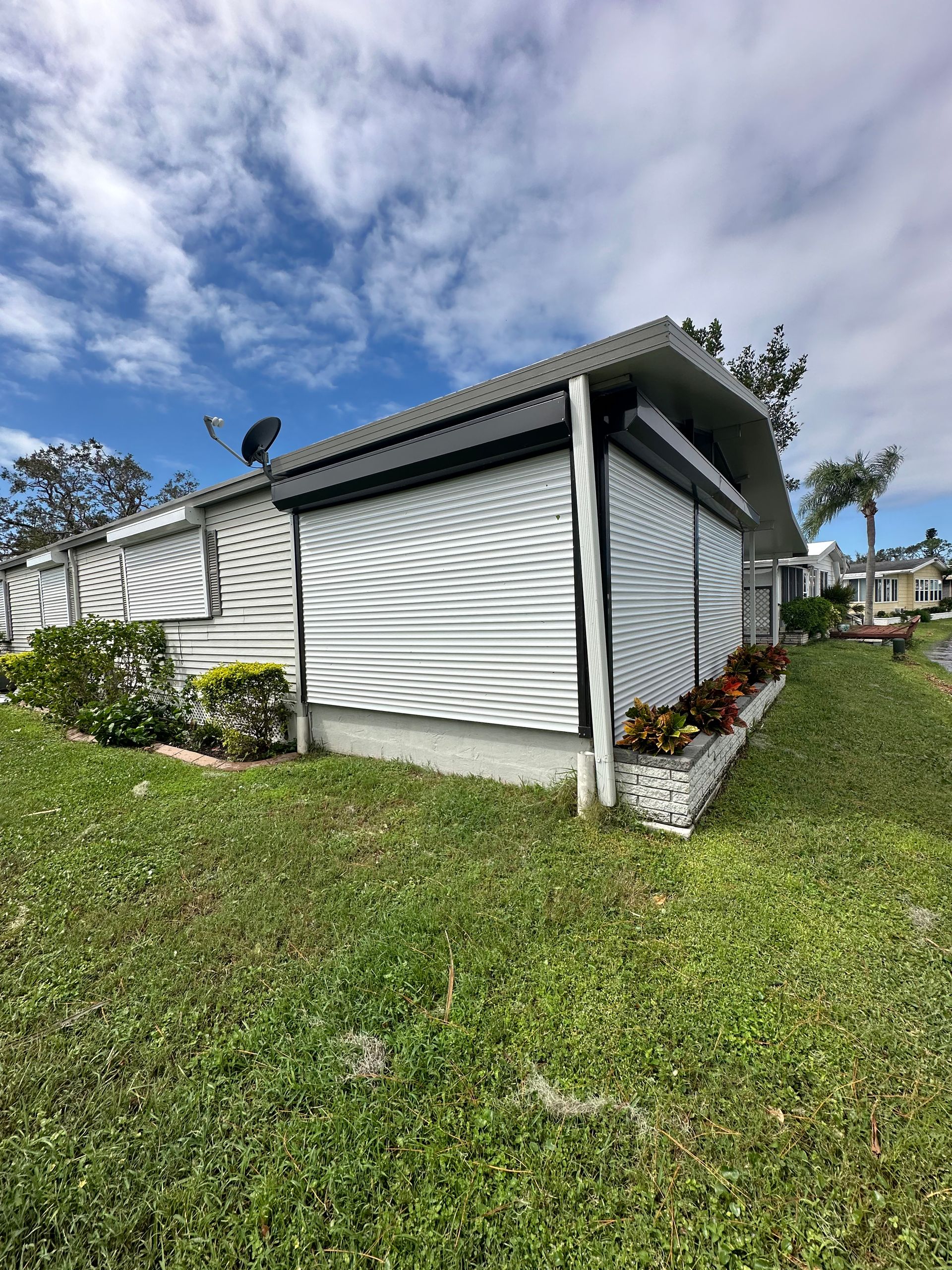 A mobile home is sitting in the middle of a lush green field.