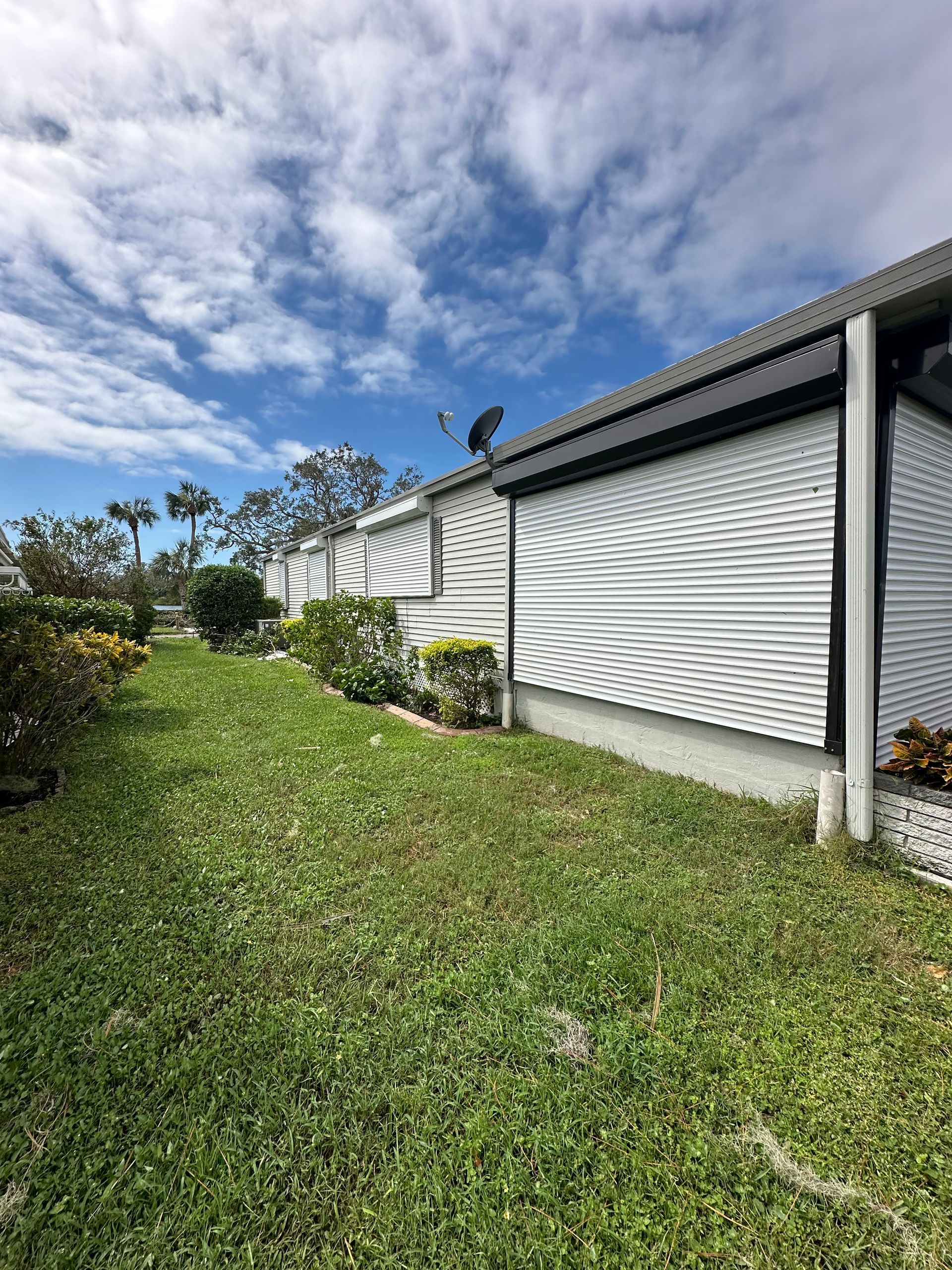 A mobile home with a lot of grass in front of it.