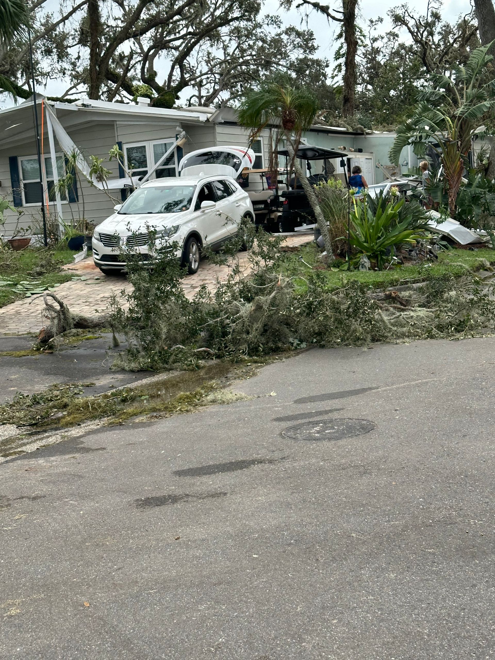 A white car is parked in front of a mobile home.