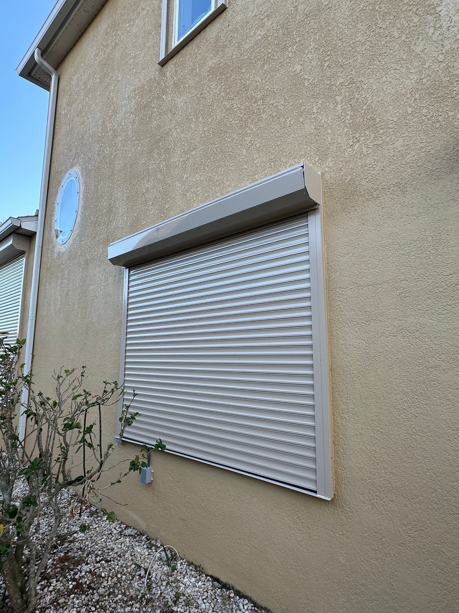 A house with a window with roller shutters on it