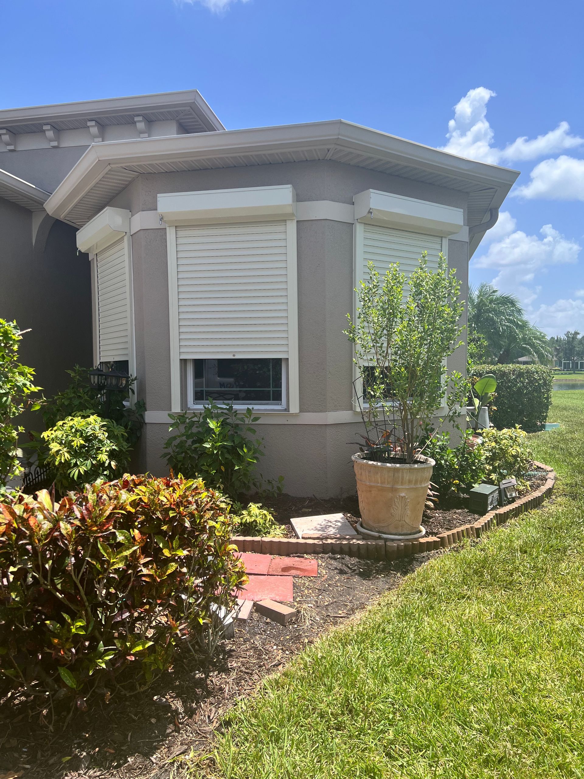 A white building with three windows and shutters on it