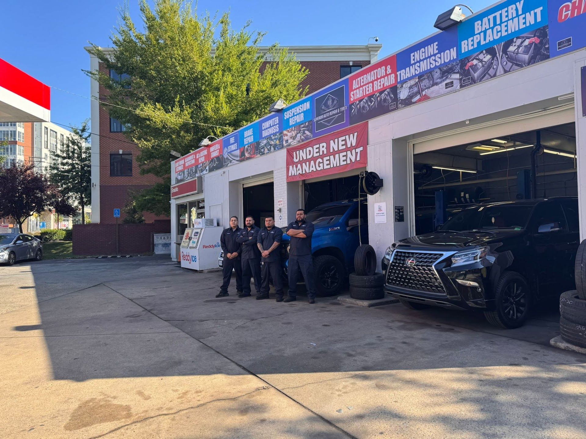 Four people stand outside an automotive repair shop | Superior Auto Repair and Tires