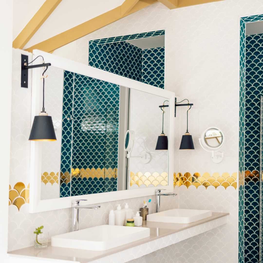 Person in a suit using a stylus on a tablet at a desk, with a toy house and calculator.