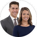 Smiling man and woman in business attire, posing together.