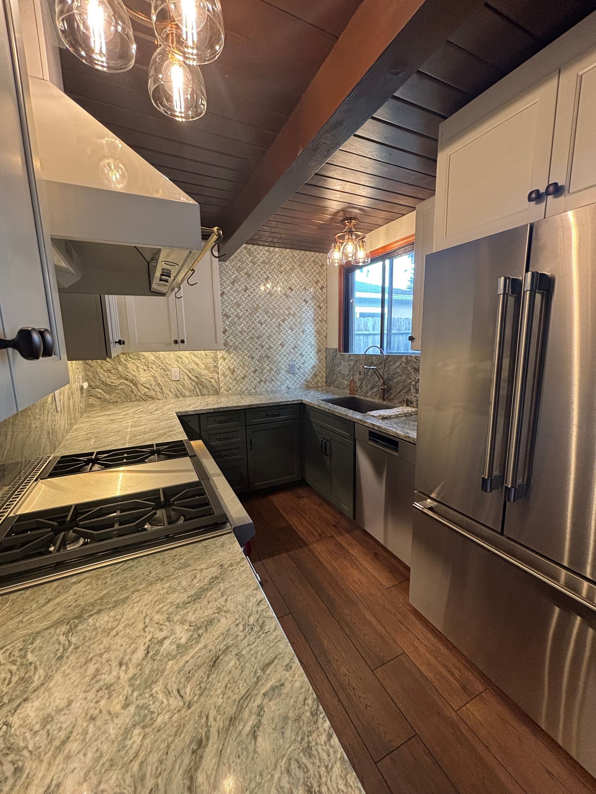 Kitchen with granite countertops, stainless steel appliances, and wood floors.