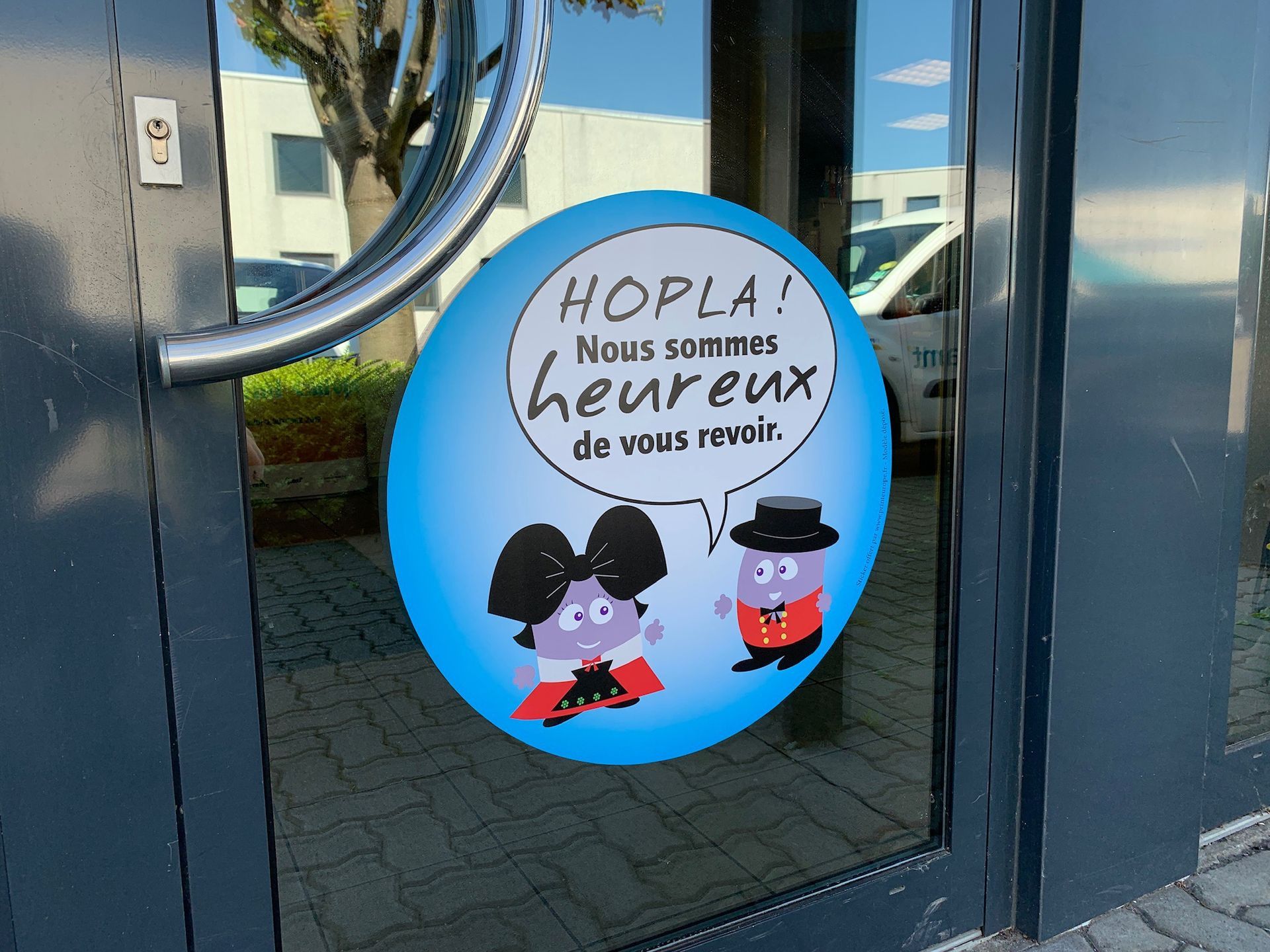 A sign on a door that says hopla nous sommes heureux de vous revoir