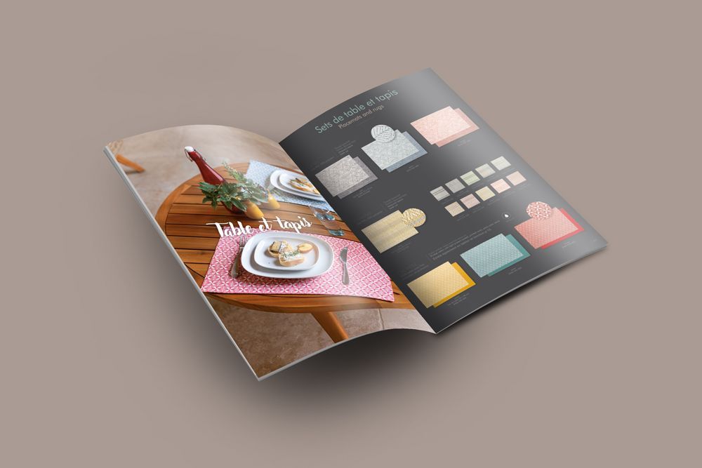 Une brochure est ouverte sur une table avec des assiettes et des serviettes dessus.