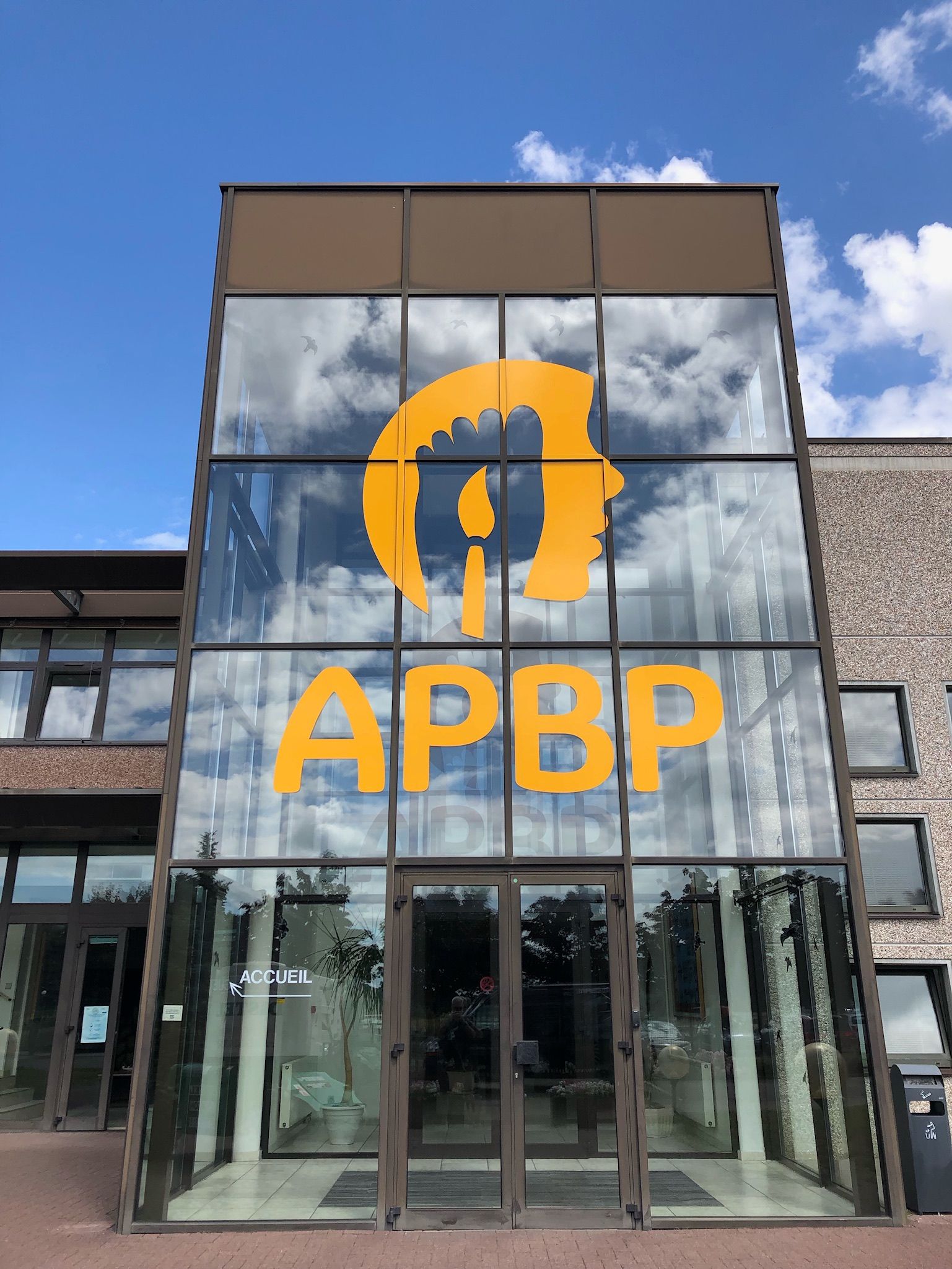Un grand bâtiment avec une grande fenêtre sur laquelle est écrit APBP