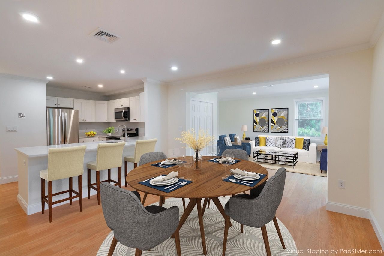 Open-concept kitchen with an island, dining table, and living area in a modern apartment.