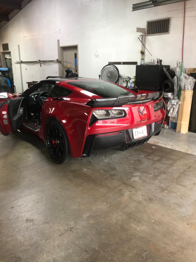 A red sports car is parked in a garage.