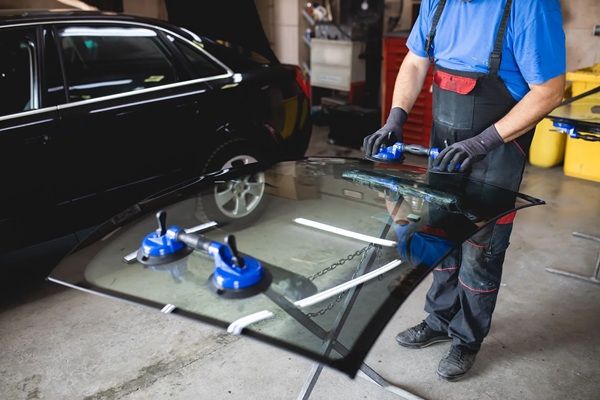 A man is replacing a broken auto glass.