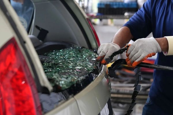 A technician works on a vehicle with a glass panel at MS Glass Outlet, offering auto glass repair in