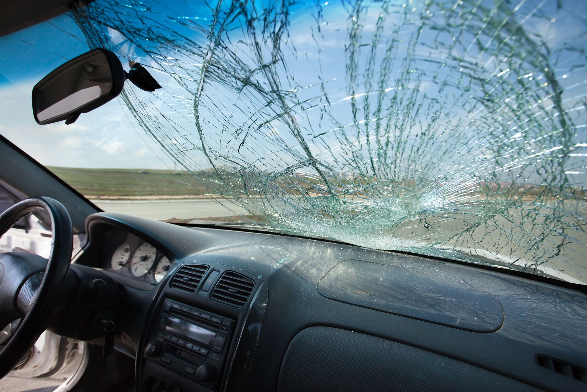 Interior view of a car with a shattered windshield from an accident.